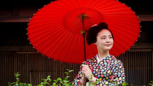 A woman in traditional Japanese attire holding a red parasol, showcasing cultural elegance., tags: japanse te - pexel