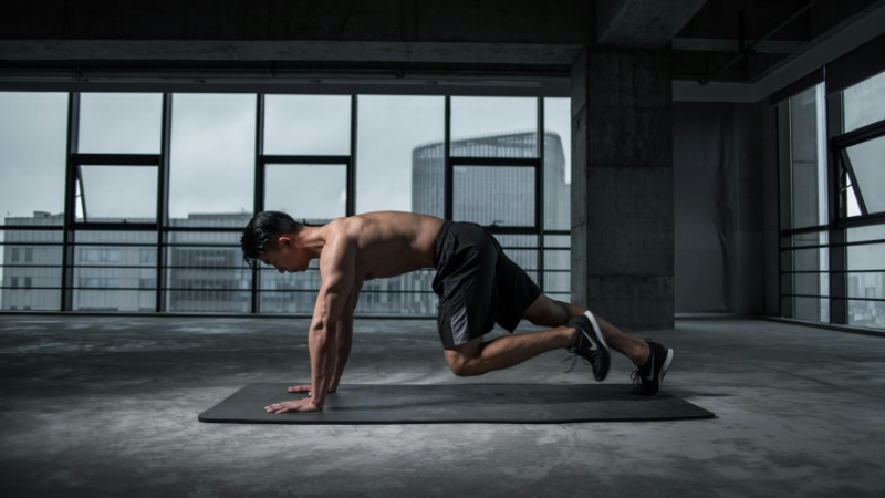 Fit man doing mountain climbers exercise inside a modern gym, tags: en - pexel